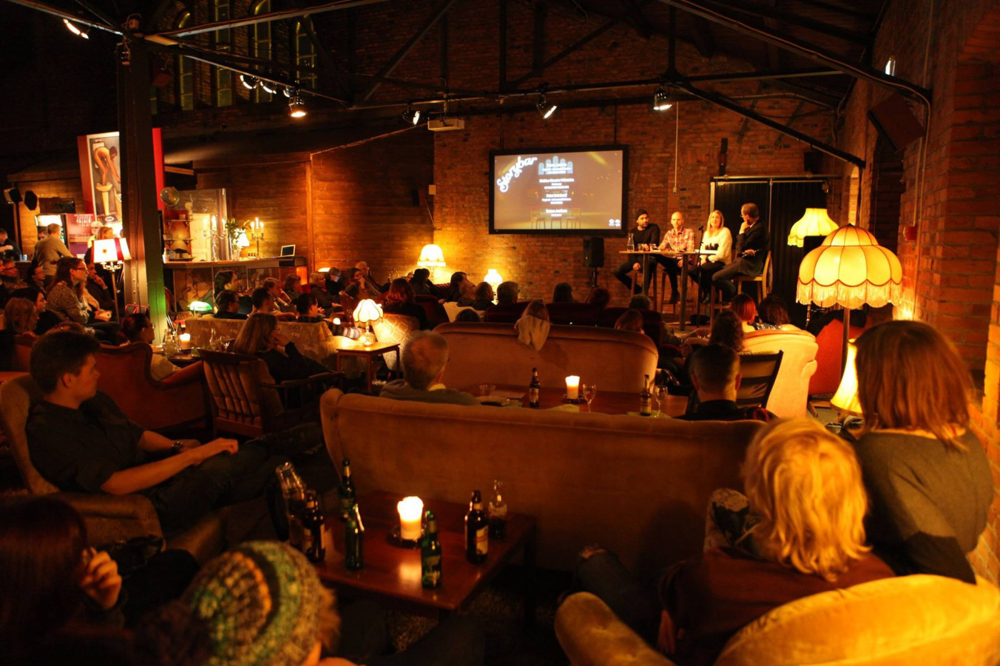 Bild på publik som ser på film i mysig publokal.