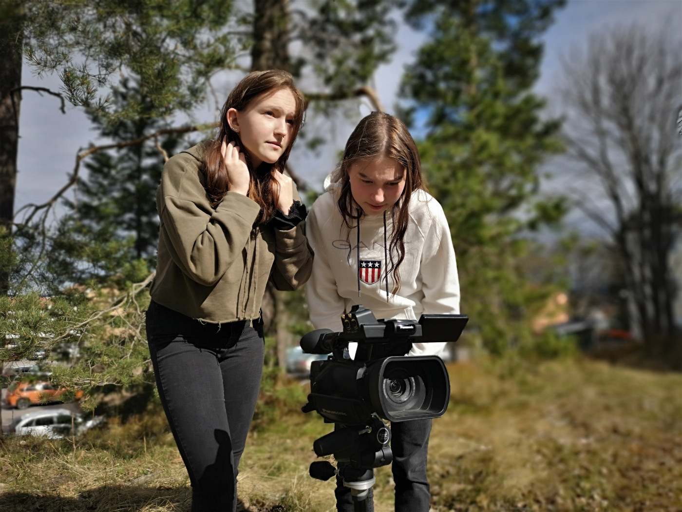 två tjejer filmar med en filmkamera