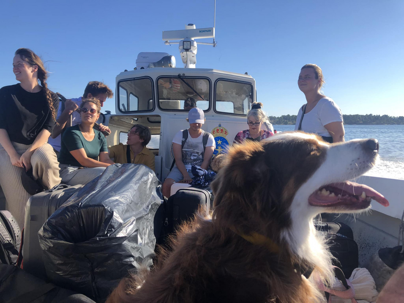 Människor och hund på öppen båt. 
