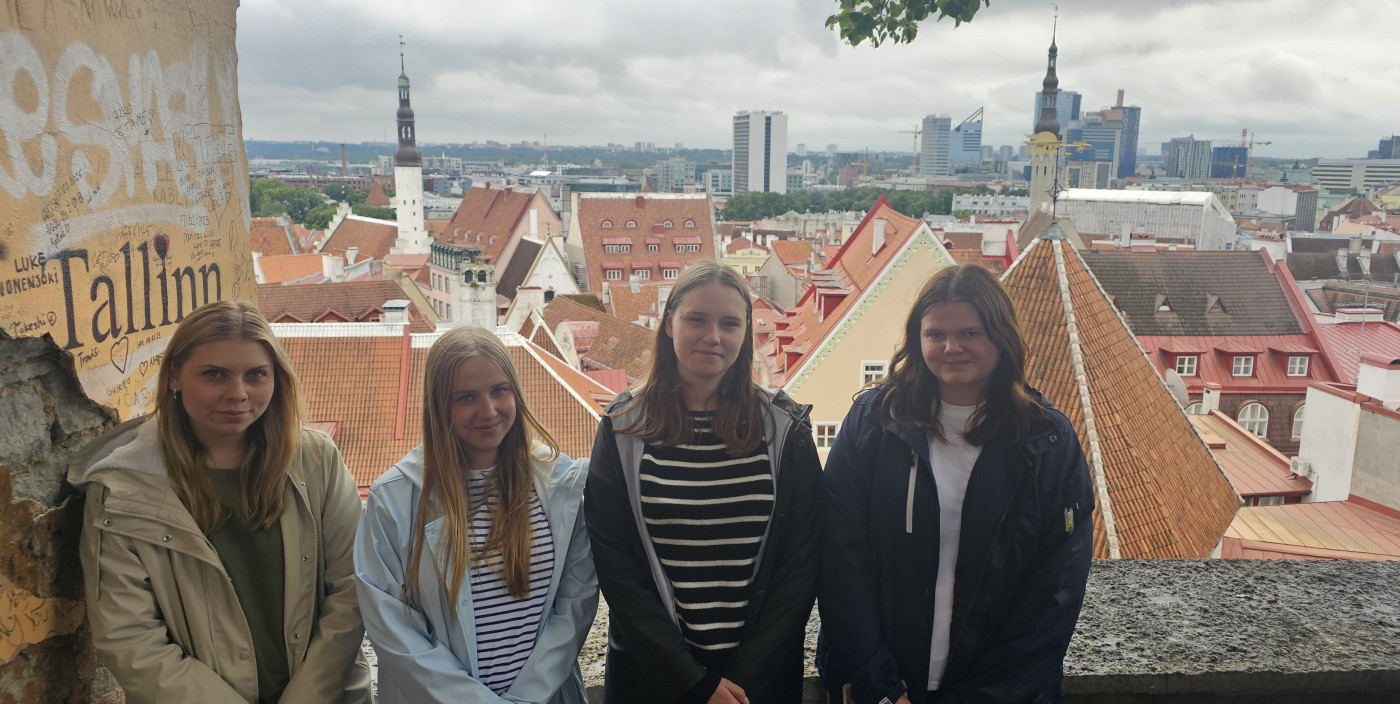 Fyra tjejer Stina, Meja, Isabell och Maja med staden Tallinn i bakgrunden.